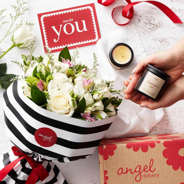 A gorgeous bouquet of fresh flowers and a hand poured candle.
