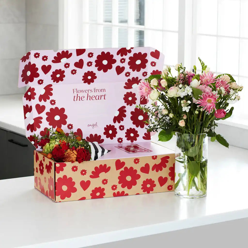 Angel Delivery flower box open with bouquet beside it in a glass vase on kitchen counter