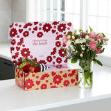 Angel Delivery flower box open with bouquet beside it in a glass vase on kitchen counter