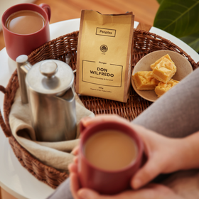 Don Wilfredo plunger coffee with caramel slice and warm brew on a tray.